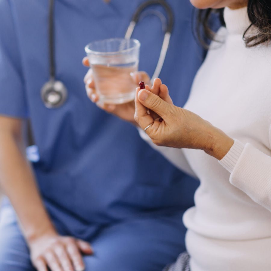Homecare nursing service and elderly people cardiology healthcare. Close up of young hispanic female doctor nurse check mature caucasian man patient heartbeat using stethoscope during visit